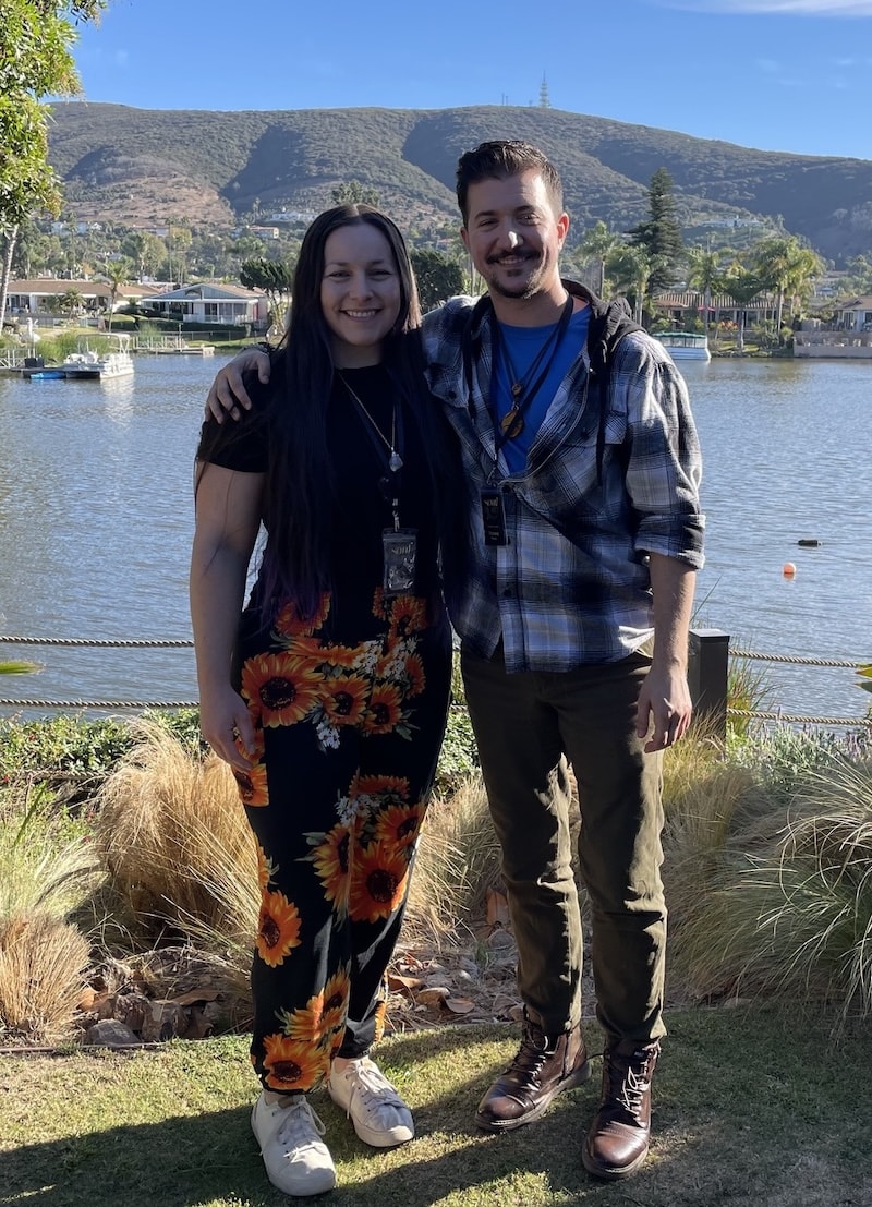 A couple standing in front of a lake